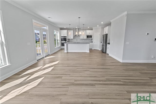 unfurnished living room featuring light wood-style floors, baseboards, and crown molding