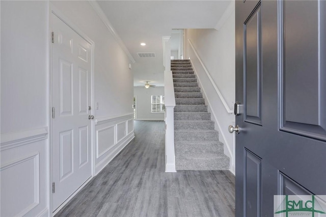 foyer featuring crown molding, ceiling fan, and wood-type flooring