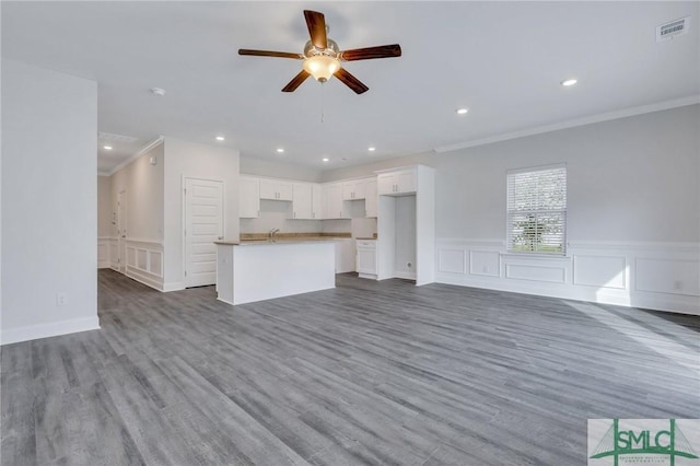 unfurnished living room featuring crown molding, hardwood / wood-style floors, and ceiling fan