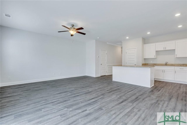 kitchen with sink, ceiling fan, light hardwood / wood-style floors, white cabinets, and a kitchen island