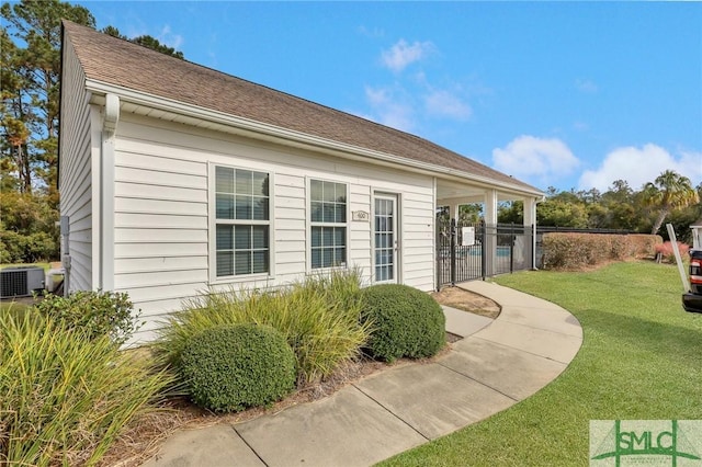 view of side of property featuring cooling unit and a yard