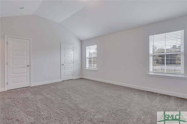 spare room featuring vaulted ceiling and carpet