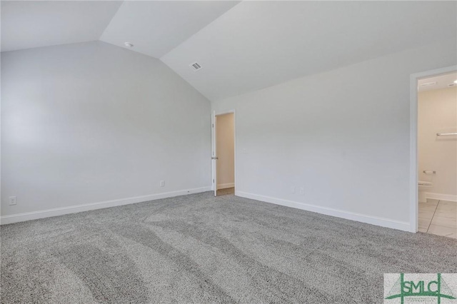 unfurnished room with lofted ceiling and light carpet