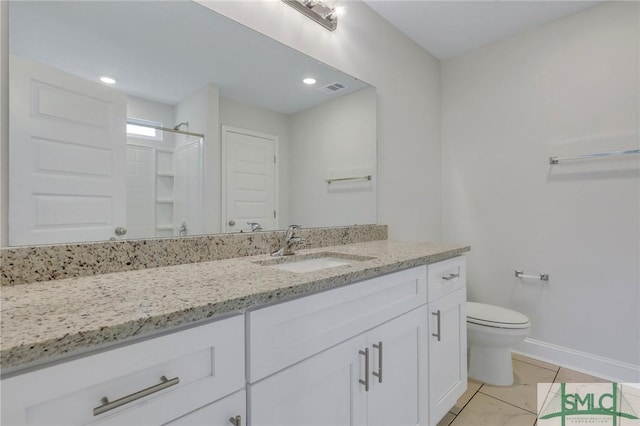 bathroom featuring walk in shower, vanity, toilet, and tile patterned flooring