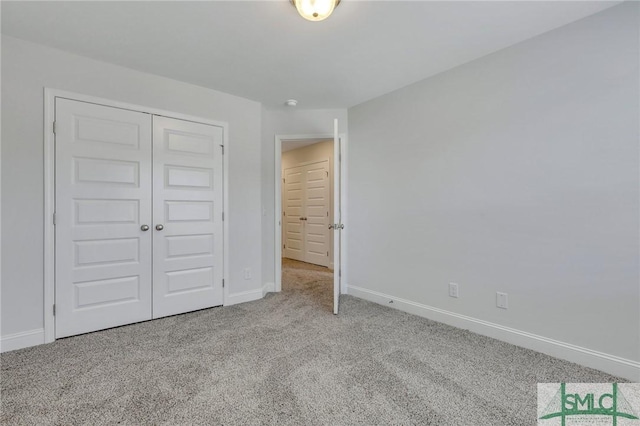 unfurnished bedroom featuring light colored carpet and a closet