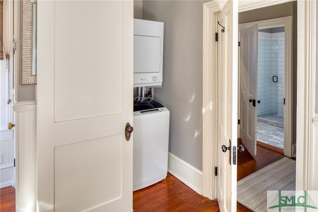 laundry area featuring dark hardwood / wood-style floors and stacked washing maching and dryer