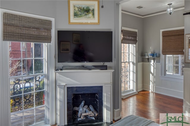 living room featuring hardwood / wood-style floors, a wealth of natural light, and ornamental molding