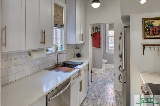 kitchen featuring white cabinets, plenty of natural light, and backsplash