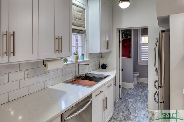 kitchen featuring white cabinetry, tasteful backsplash, appliances with stainless steel finishes, and sink