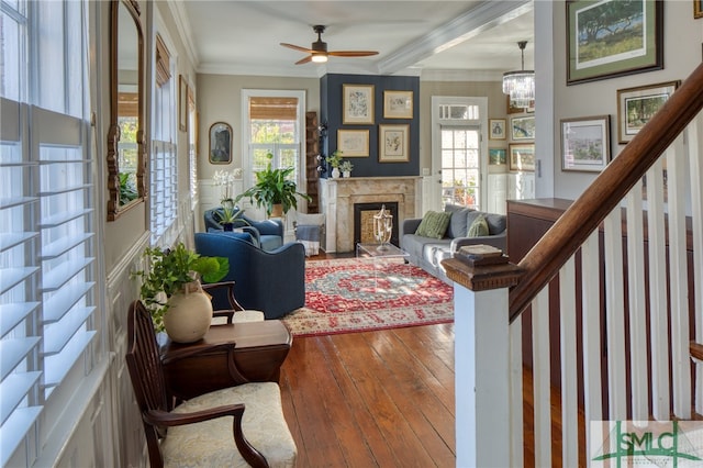 living room with a fireplace, ceiling fan with notable chandelier, a wealth of natural light, and wood-type flooring