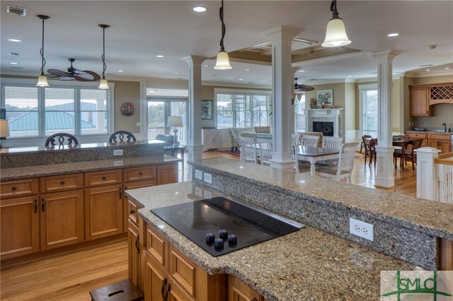 kitchen with black electric cooktop, crown molding, light hardwood / wood-style floors, and pendant lighting