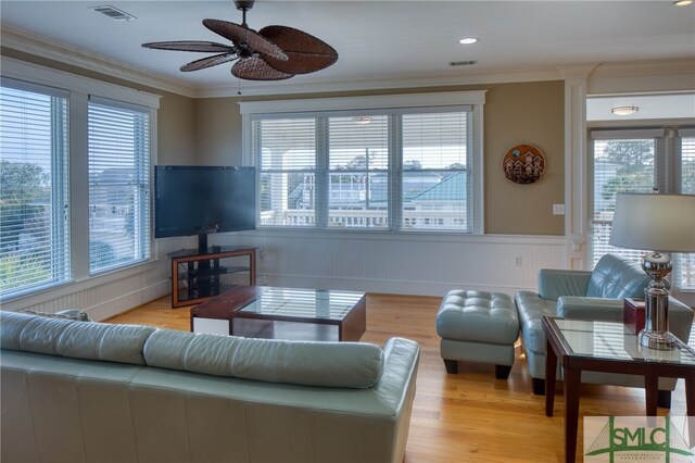 living room with ornamental molding, ceiling fan, and light wood-type flooring