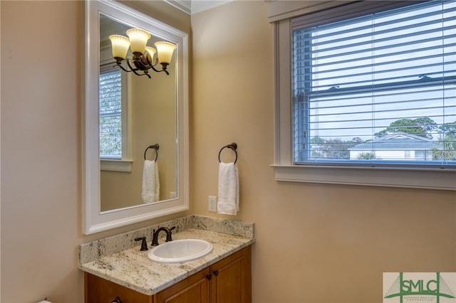 bathroom featuring a notable chandelier, large vanity, and a wealth of natural light