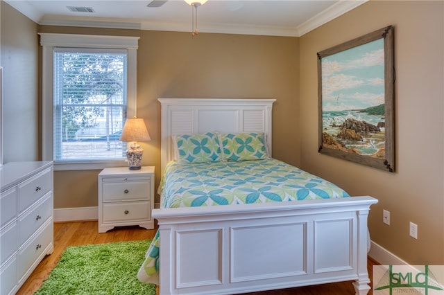 bedroom with crown molding, ceiling fan, and light hardwood / wood-style flooring