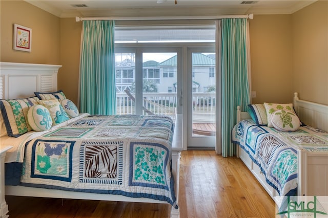 bedroom featuring light hardwood / wood-style flooring, access to exterior, crown molding, and multiple windows