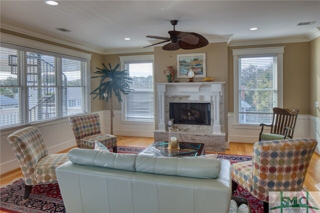 living room featuring plenty of natural light, a high end fireplace, and light hardwood / wood-style flooring