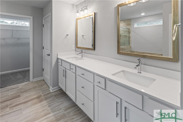 bathroom featuring vanity, a wealth of natural light, and walk in shower