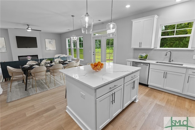 kitchen featuring pendant lighting, white cabinetry, sink, a center island, and stainless steel dishwasher