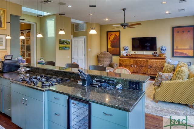 kitchen featuring beverage cooler, a kitchen island, ceiling fan, and dark hardwood / wood-style flooring