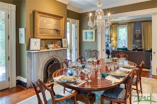 dining area featuring an inviting chandelier, ornamental molding, and hardwood / wood-style flooring