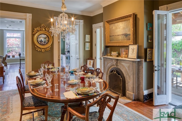 dining area featuring crown molding, french doors, a notable chandelier, and light hardwood / wood-style flooring