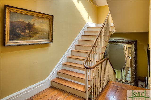 stairway with light hardwood / wood-style floors