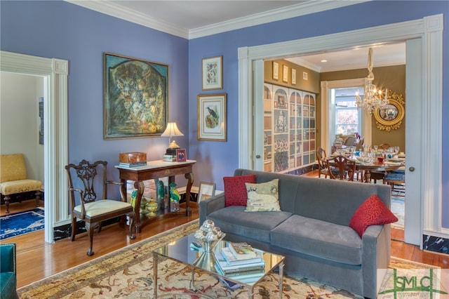 living room with a notable chandelier, hardwood / wood-style floors, and ornamental molding