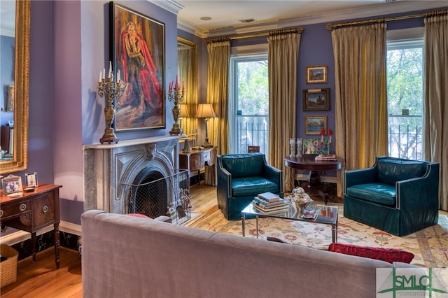 living room featuring ornamental molding, a healthy amount of sunlight, and light hardwood / wood-style floors