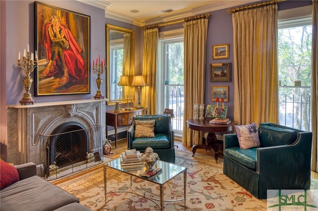 living room featuring light hardwood / wood-style flooring, crown molding, and a healthy amount of sunlight