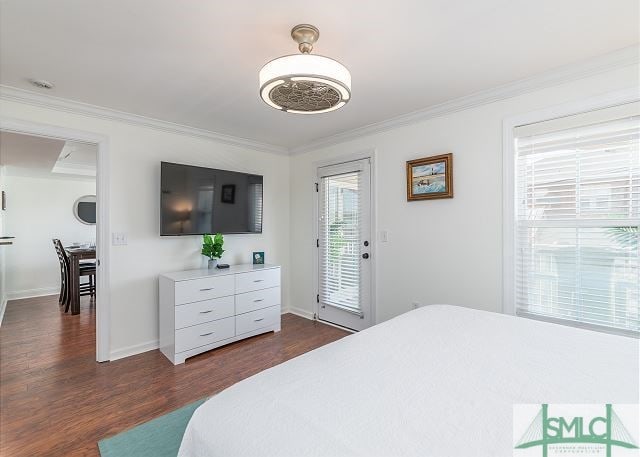 bedroom with baseboards, access to exterior, crown molding, and dark wood-style flooring