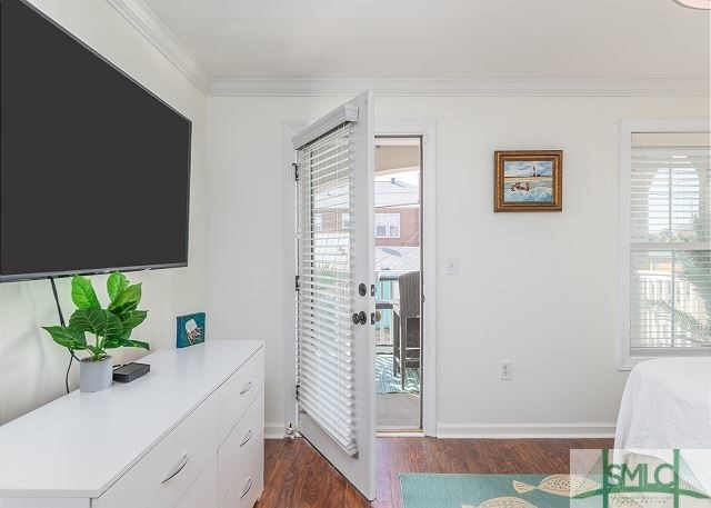 entryway featuring dark wood finished floors, baseboards, and crown molding