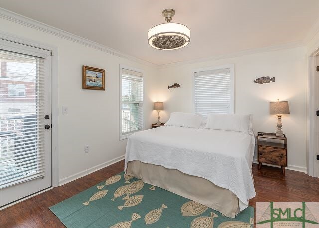 bedroom with baseboards, wood finished floors, and ornamental molding