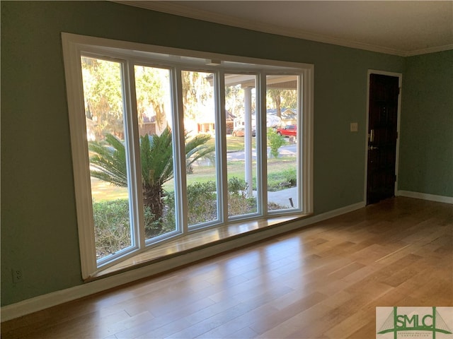 spare room with ornamental molding and light hardwood / wood-style flooring