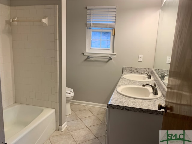 full bathroom featuring dual sinks, toilet, tiled shower / bath, large vanity, and tile floors