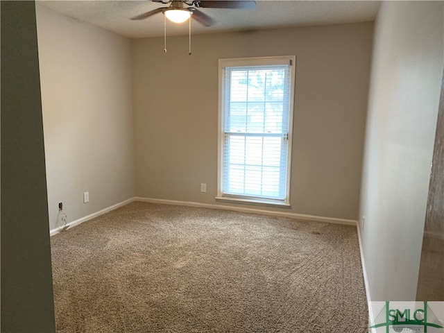 carpeted spare room with ceiling fan and plenty of natural light