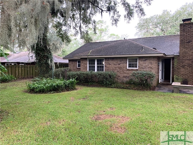 rear view of property with a lawn