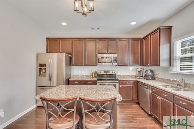 kitchen featuring dark hardwood / wood-style floors, a center island, appliances with stainless steel finishes, and sink