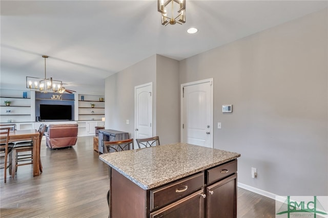 kitchen with pendant lighting, a kitchen island, dark brown cabinets, and dark hardwood / wood-style flooring