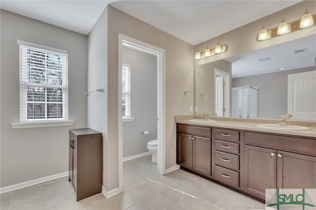 bathroom with plenty of natural light, tile flooring, toilet, and dual bowl vanity