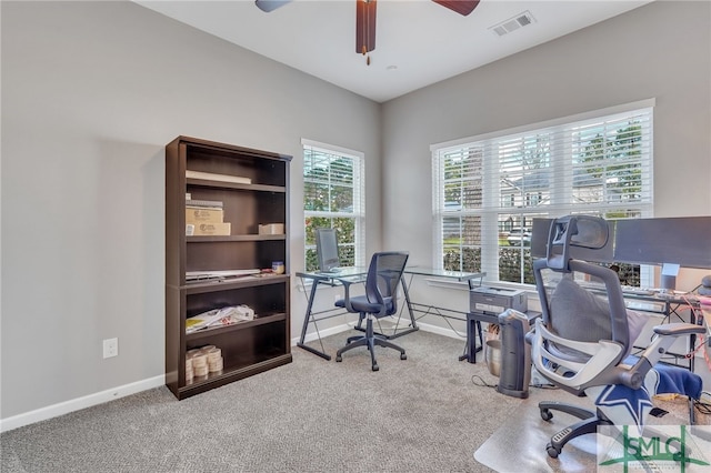 carpeted office space with ceiling fan