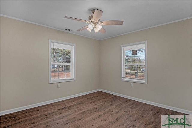 empty room with a healthy amount of sunlight, ceiling fan, ornamental molding, and dark wood-type flooring