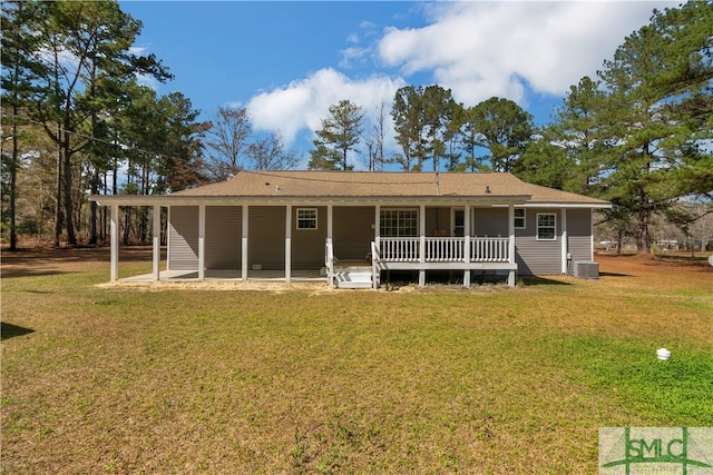 rear view of property with central AC unit and a lawn