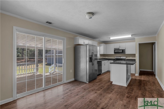 kitchen featuring stainless steel appliances, a kitchen island, ornamental molding, white cabinets, and dark hardwood / wood-style flooring