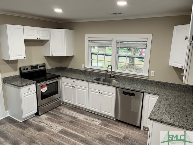 kitchen with crown molding, hardwood / wood-style floors, sink, white cabinets, and appliances with stainless steel finishes