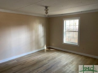 empty room with light hardwood / wood-style flooring and ornamental molding