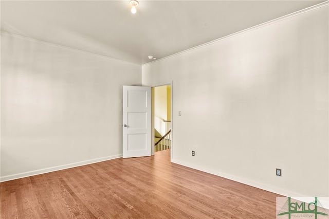 empty room with crown molding and hardwood / wood-style floors