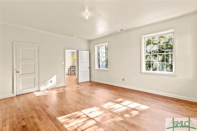 unfurnished bedroom with ornamental molding, light hardwood / wood-style flooring, and multiple windows