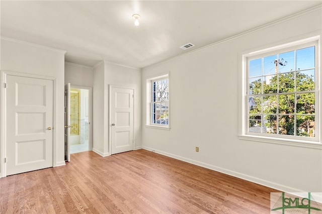 unfurnished bedroom with crown molding, ensuite bath, and light hardwood / wood-style floors