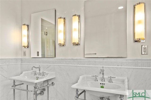 bathroom with tile walls, sink, and walk in shower