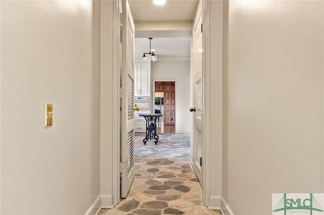 hall featuring crown molding and an inviting chandelier